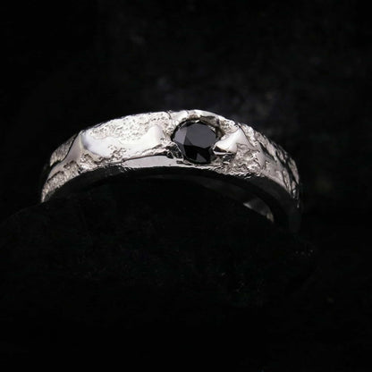 Detalle macro del engarce de la circonita negra talla brillante en el anillo de plata forjada a mano.