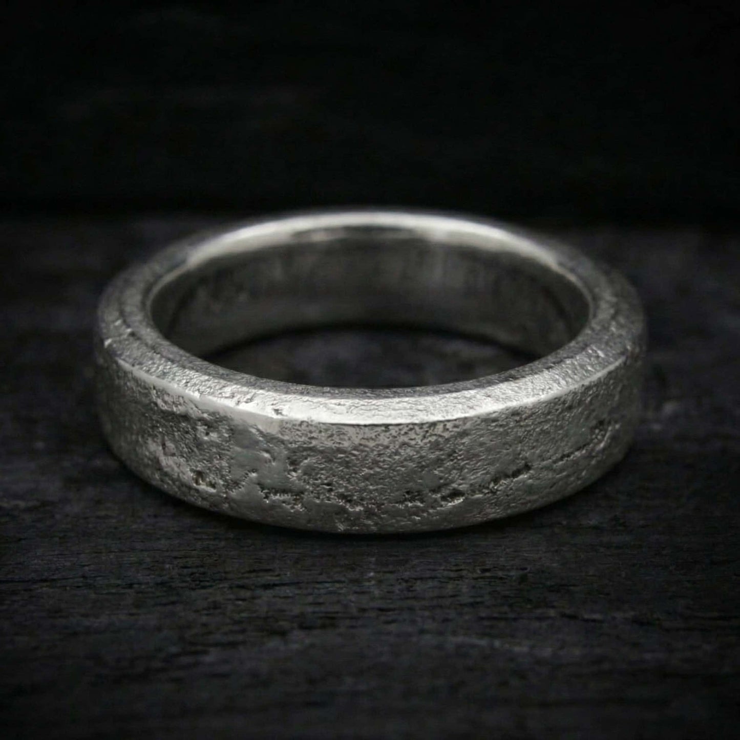 Macro de acabado semipulido con brillo en relieves y fondo mate arena en anillo de plata.