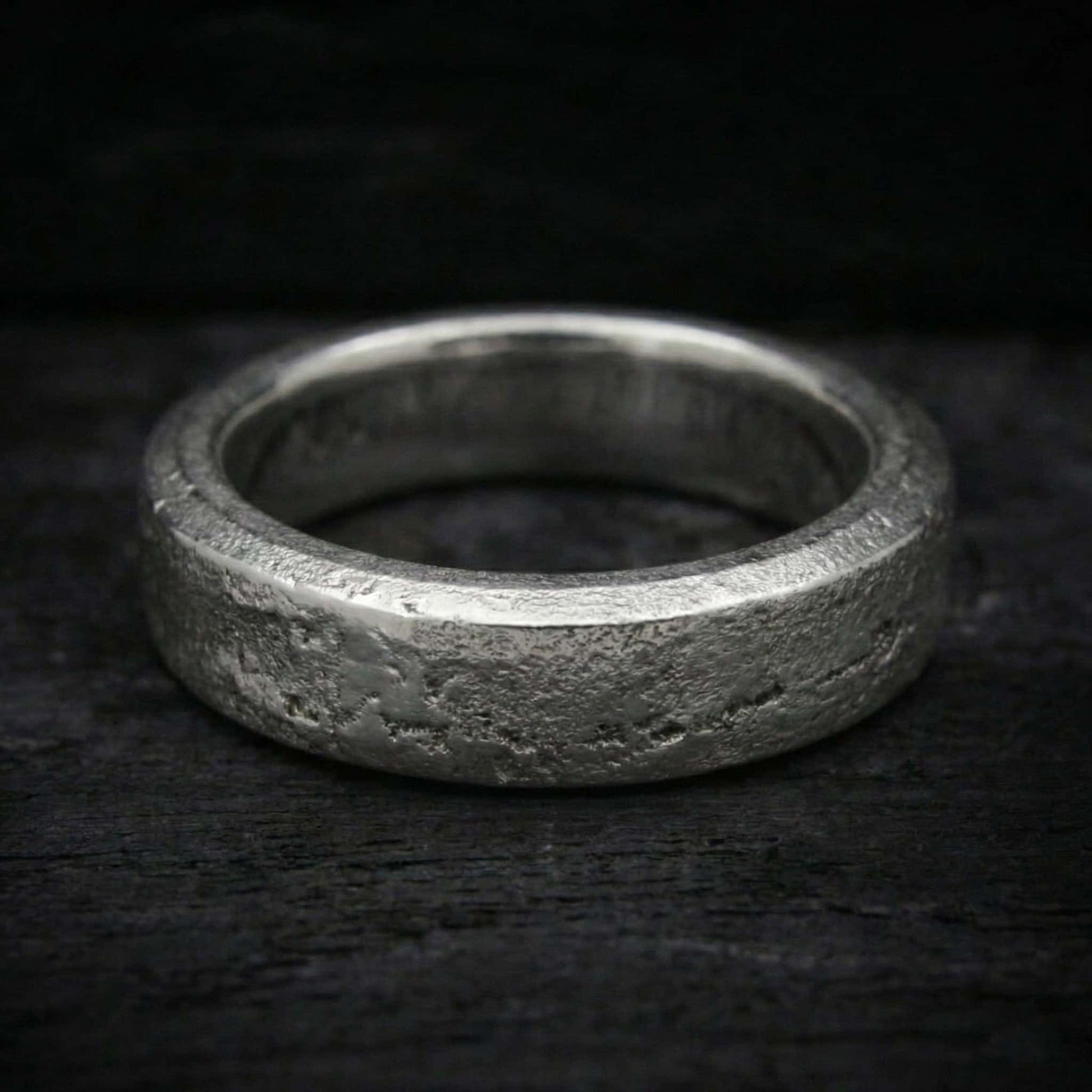 Macro de acabado semipulido con brillo en relieves y fondo mate arena en anillo de plata.