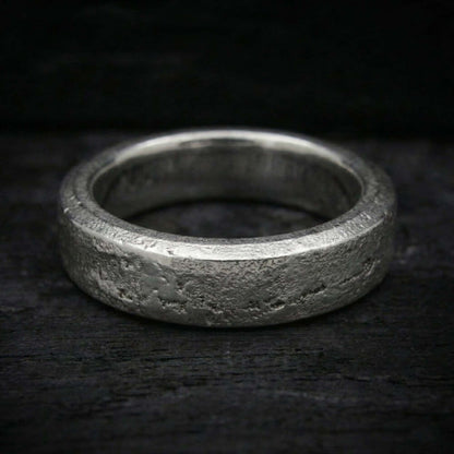 Macro de acabado semipulido con brillo en relieves y fondo mate arena en anillo de plata.