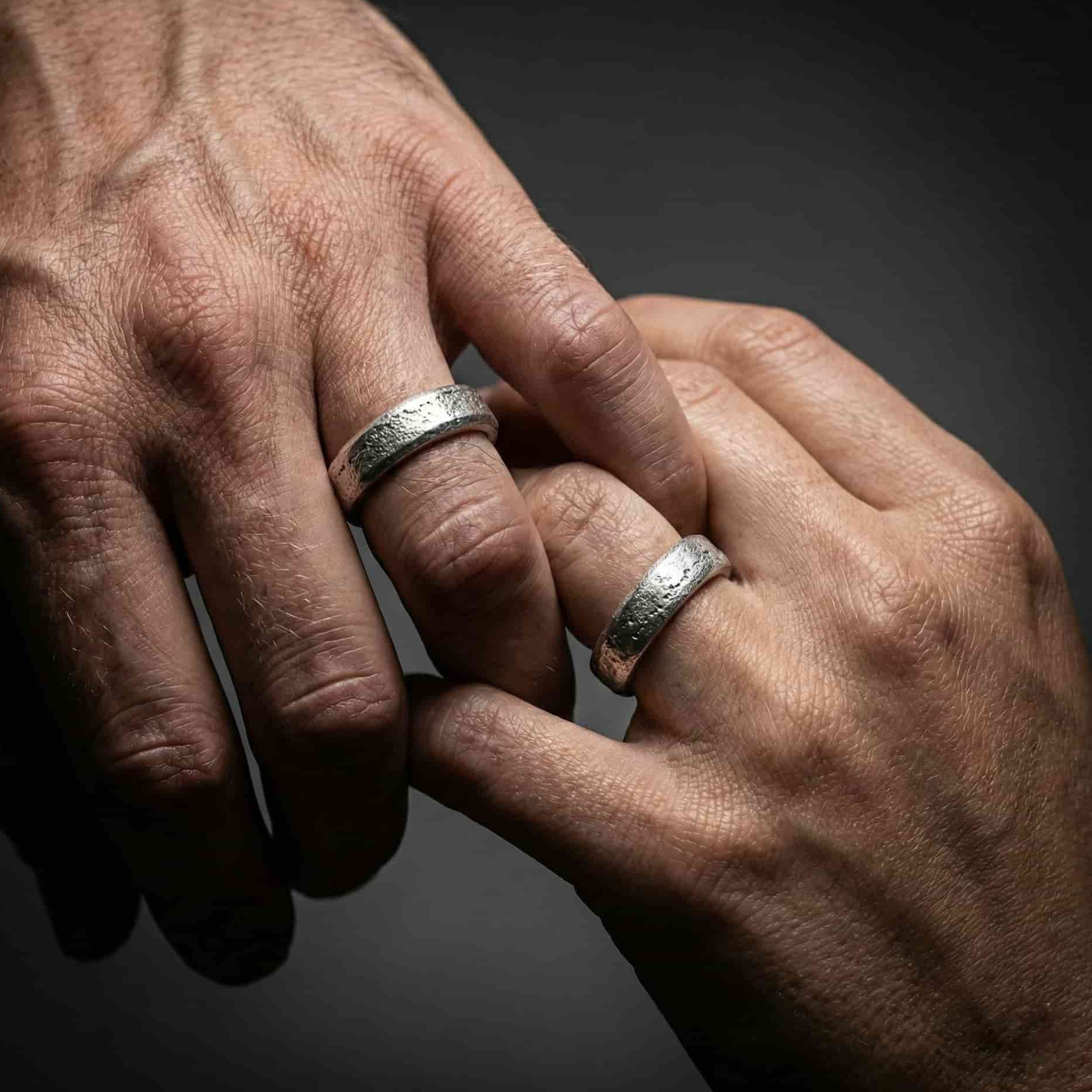 Hombre llevando el anillo Lur de 5mm. Alianza de luto robusta e indestructible con cenizas ocultas.