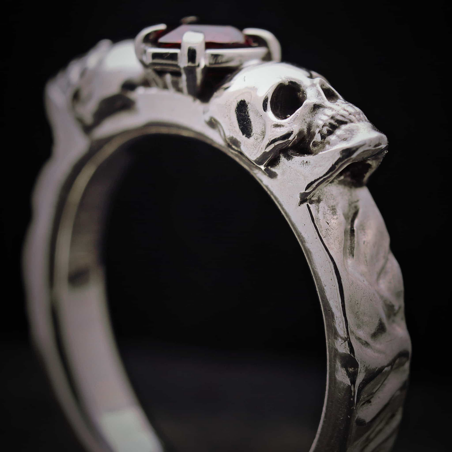 Anillo robusto de plata maciza estilo memento mori con calaveras laterales.