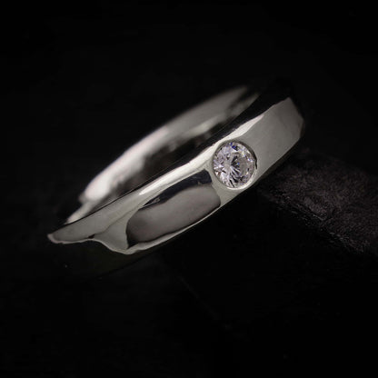 Detalle del pulido espejo y la circonita brillante en el anillo urna de plata de ley 925.