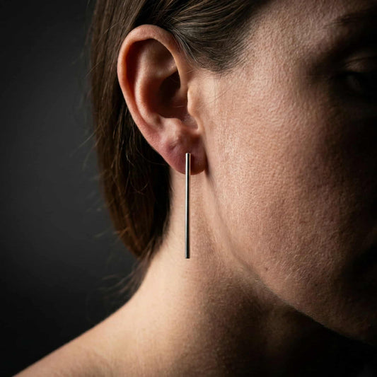 Modelo con pendientes de barra verticales de plata combinados estilo moderno.