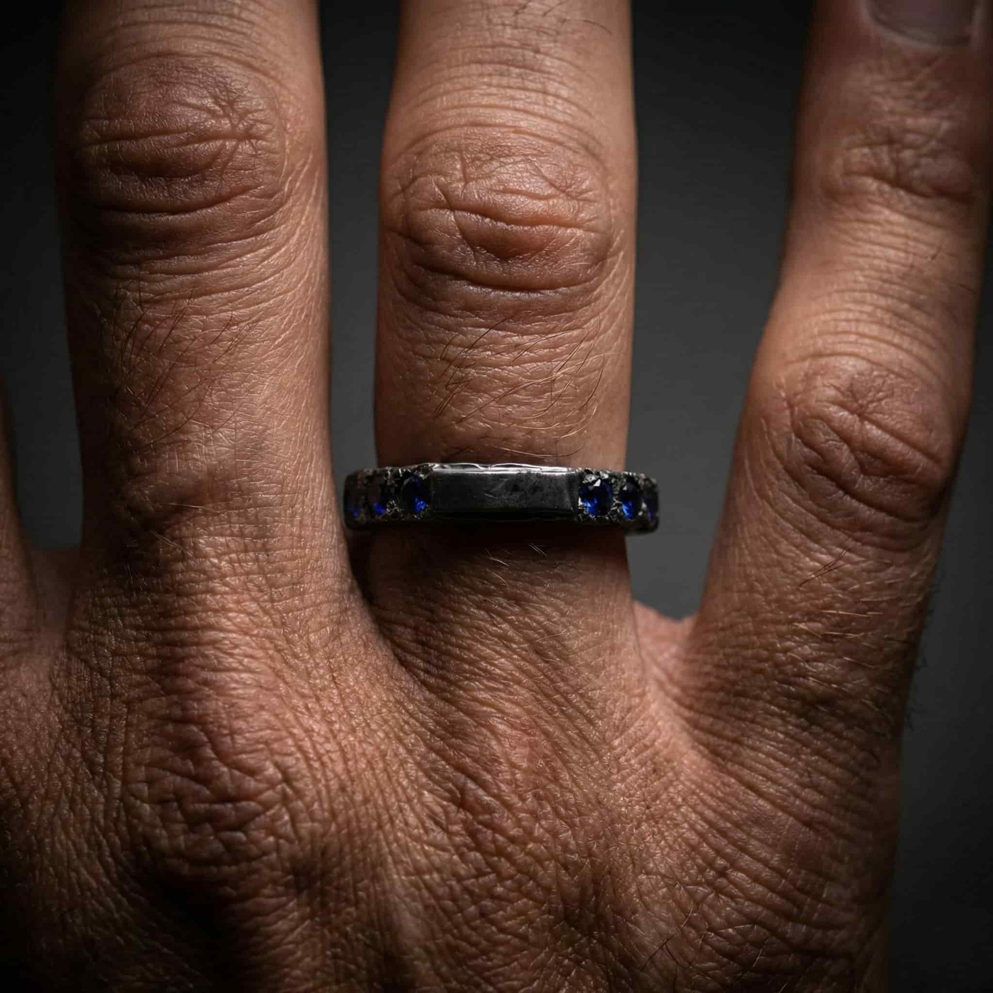 Mano de hombre con anillo de grosor extra y diseño industrial.
