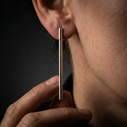 Mujer luciendo pendientes barra plata mujer en la oreja estilo casual.