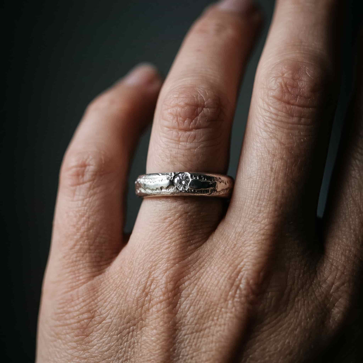 Mujer luciendo la alianza artesanal de plata con circonita de 3mm. Un anillo de compromiso alternativo y elegante.