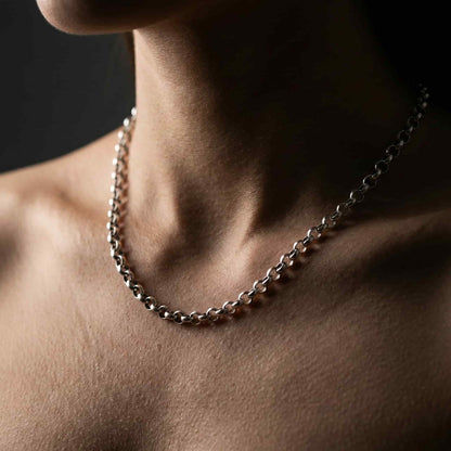 Mujer luciendo collar de eslabones redondos de plata estilo minimalista.