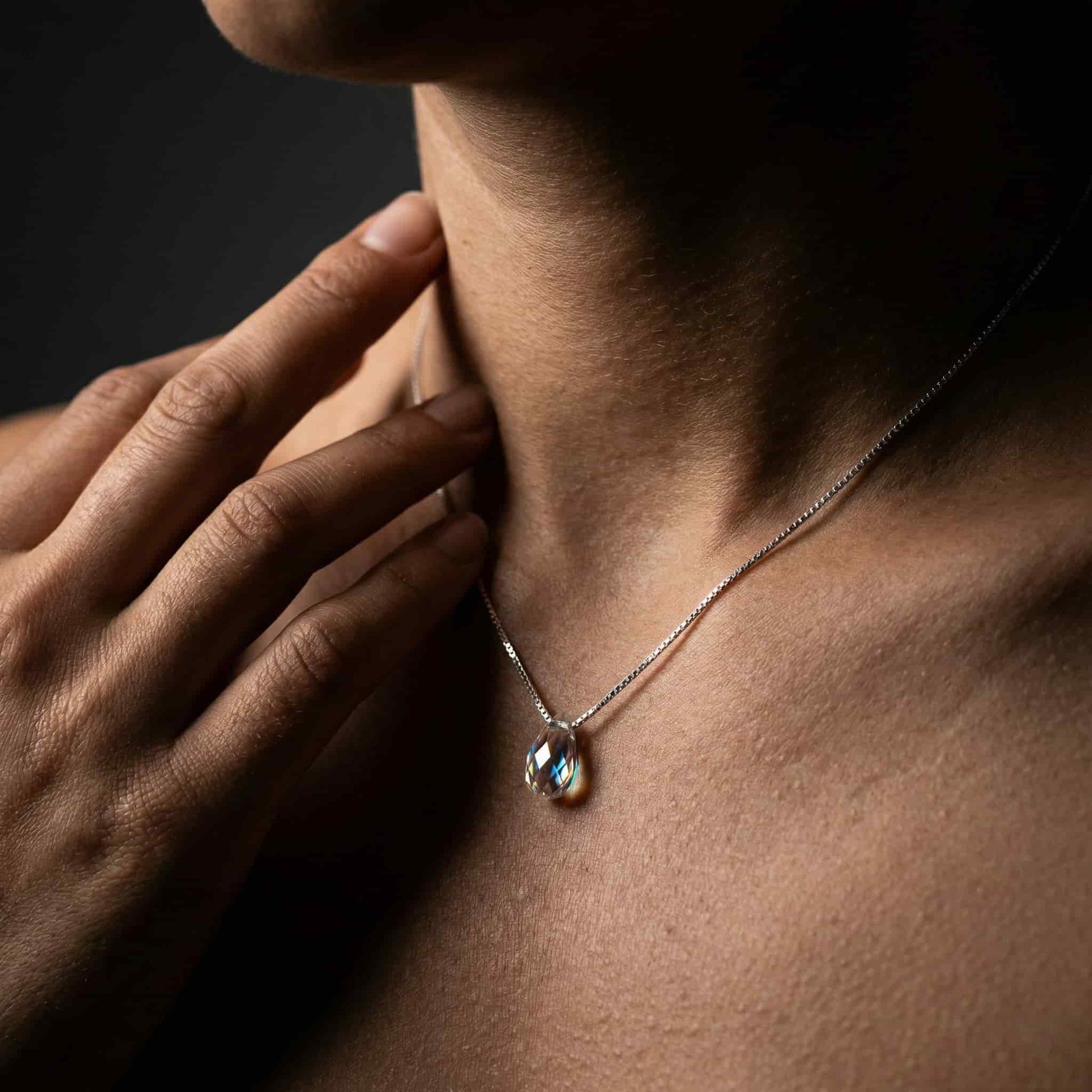 Mujer luciendo collar de plata con lágrima de cristal estilo minimalista.