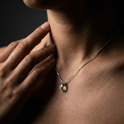 Mujer luciendo collar de plata con lágrima de cristal estilo minimalista.