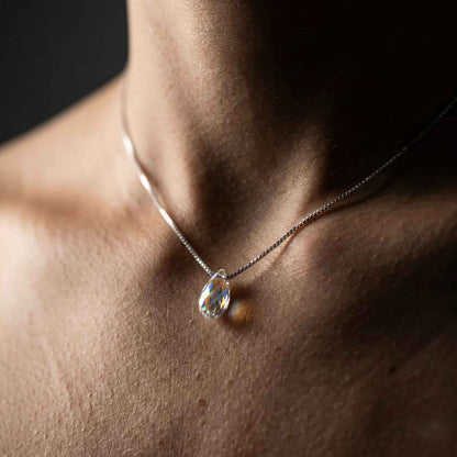 Modelo con cadena de plata veneciana y Colgante de cristal combinado con look elegante.