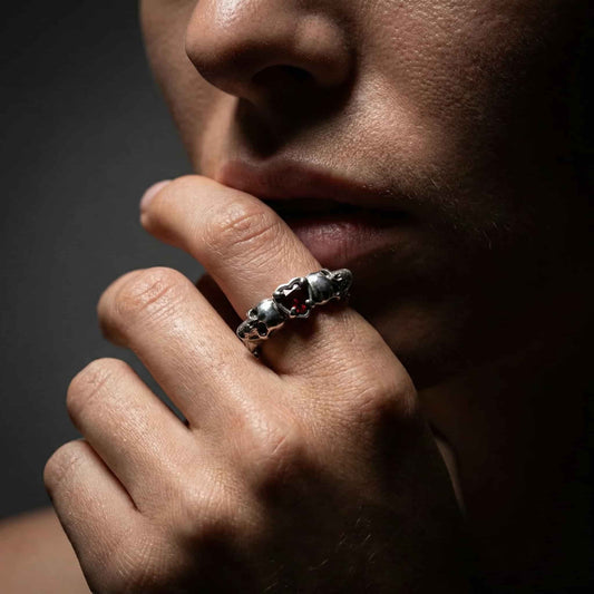 Look alternativo de mujer con anillo de calaveras de plata en el dedo índice.