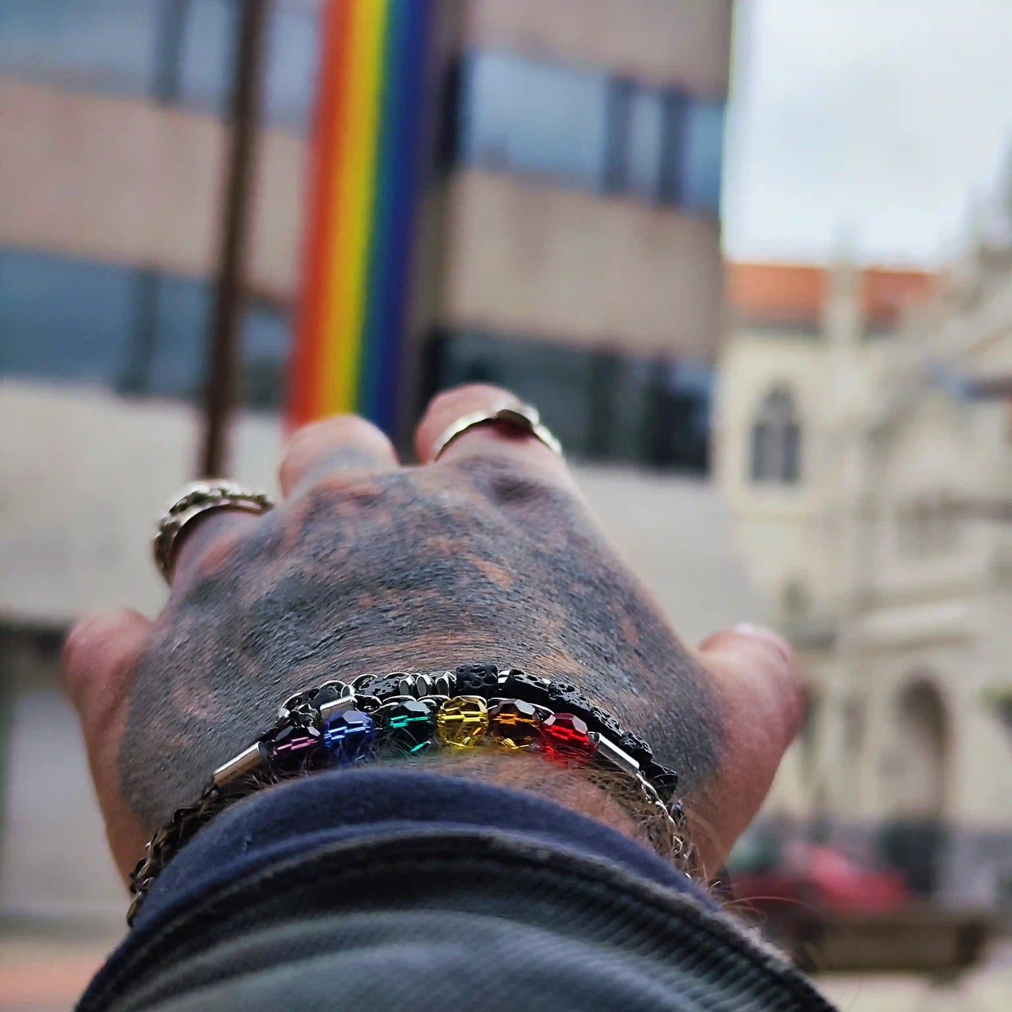 Hombre con pulsera gay de acero y cadena trenzada en la muñeca estilo casual.